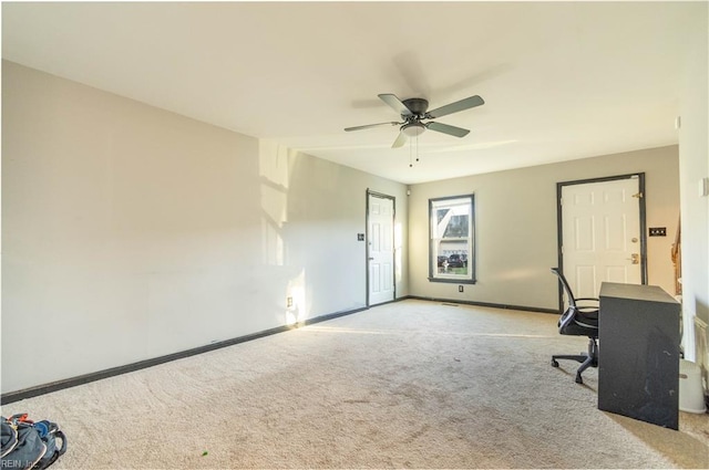 unfurnished office with ceiling fan and light colored carpet