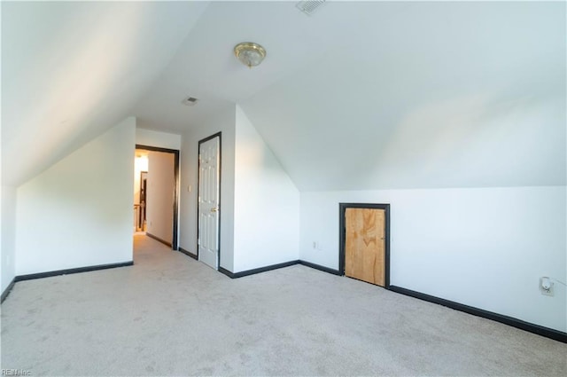 bonus room featuring vaulted ceiling and light carpet