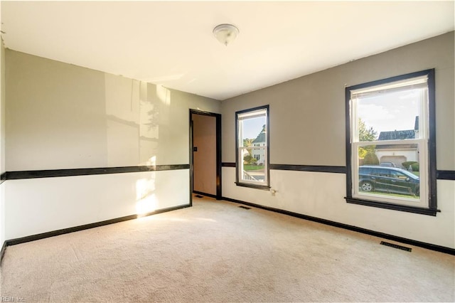 carpeted empty room with plenty of natural light