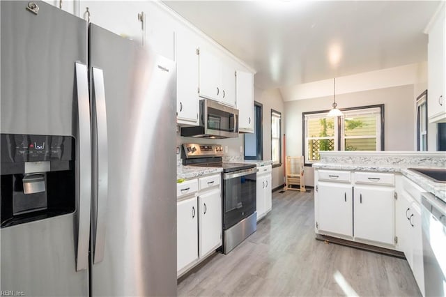 kitchen featuring appliances with stainless steel finishes, hanging light fixtures, light wood-type flooring, and white cabinets