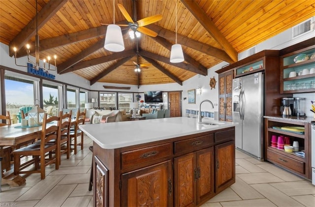 kitchen featuring an island with sink, sink, stainless steel fridge with ice dispenser, and wooden ceiling