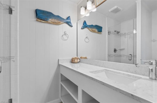 bathroom with vanity, wood walls, and an enclosed shower