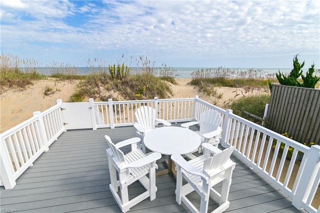 wooden deck featuring a water view and a view of the beach