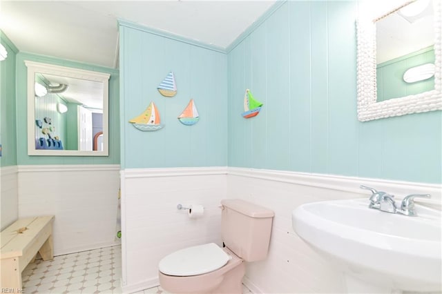 bathroom with ornamental molding, sink, and toilet