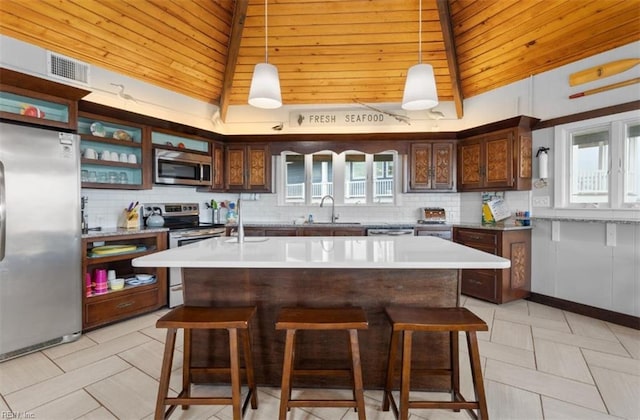 kitchen with pendant lighting, appliances with stainless steel finishes, and wooden ceiling