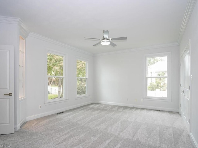 empty room with crown molding, ceiling fan, and light colored carpet