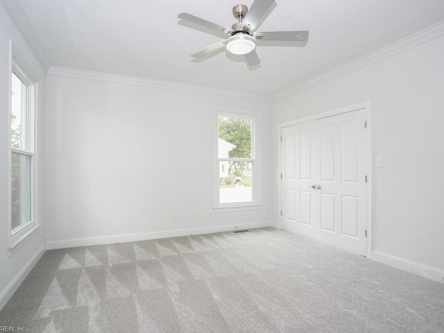 carpeted empty room featuring ceiling fan and ornamental molding