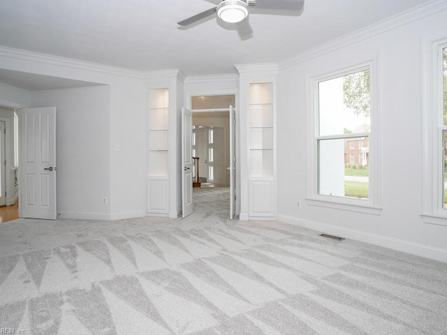 interior space with light carpet, ceiling fan, and crown molding