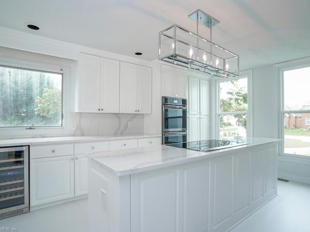 kitchen featuring white cabinets, a wealth of natural light, hanging light fixtures, and black electric cooktop