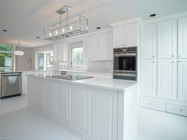 kitchen with a kitchen island, hanging light fixtures, white cabinetry, and stainless steel appliances