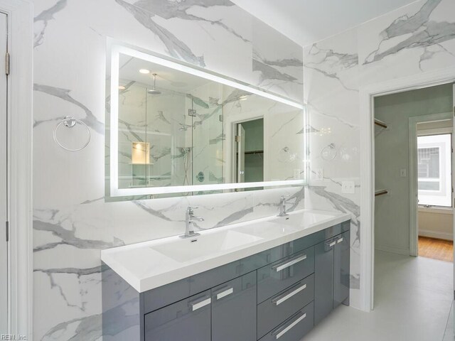 bathroom with vanity, tile walls, and a shower with shower door