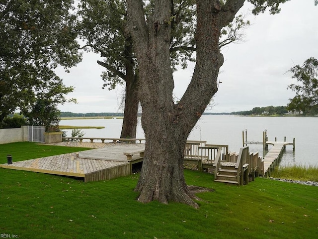 view of dock featuring a water view and a yard