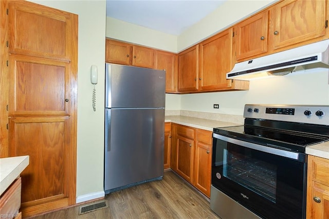 kitchen with appliances with stainless steel finishes and dark wood-type flooring