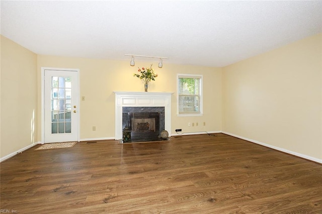 unfurnished living room featuring a fireplace and dark wood-type flooring