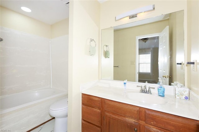 full bathroom featuring tiled shower / bath, vanity, and toilet