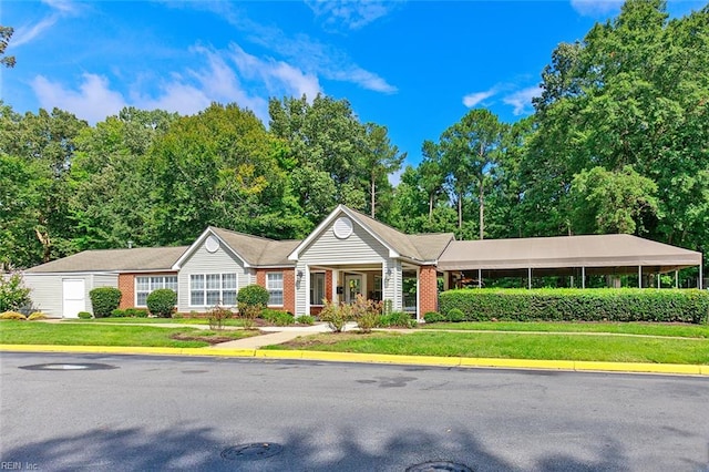 ranch-style home featuring a carport and a front lawn