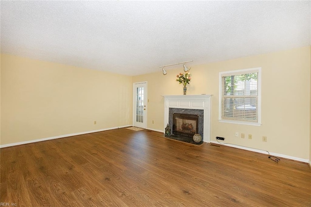 unfurnished living room featuring a textured ceiling, hardwood / wood-style floors, and a premium fireplace