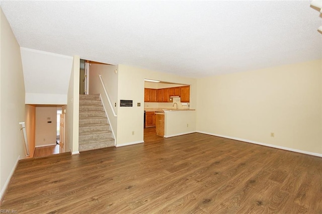 unfurnished living room featuring sink and dark wood-type flooring