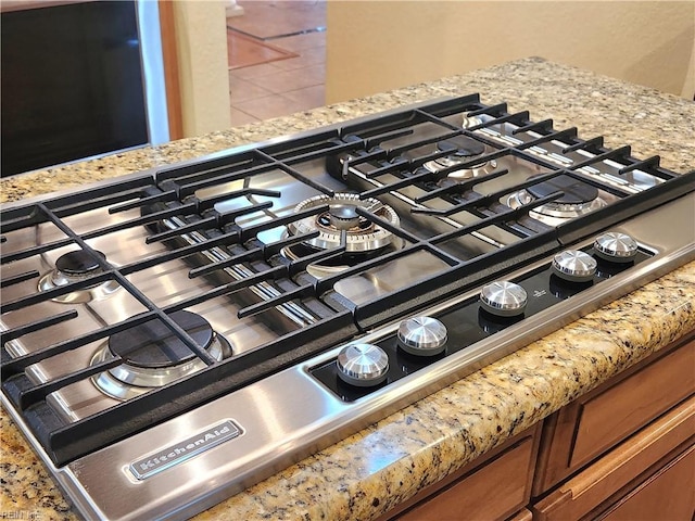 interior details featuring stainless steel gas stovetop and light stone counters