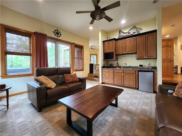 living room featuring sink, ceiling fan, and light colored carpet