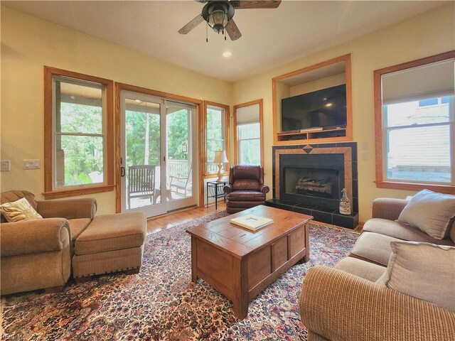 living room featuring ceiling fan, a fireplace, and hardwood / wood-style floors