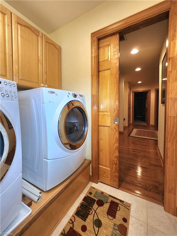 laundry room with light hardwood / wood-style flooring and cabinets