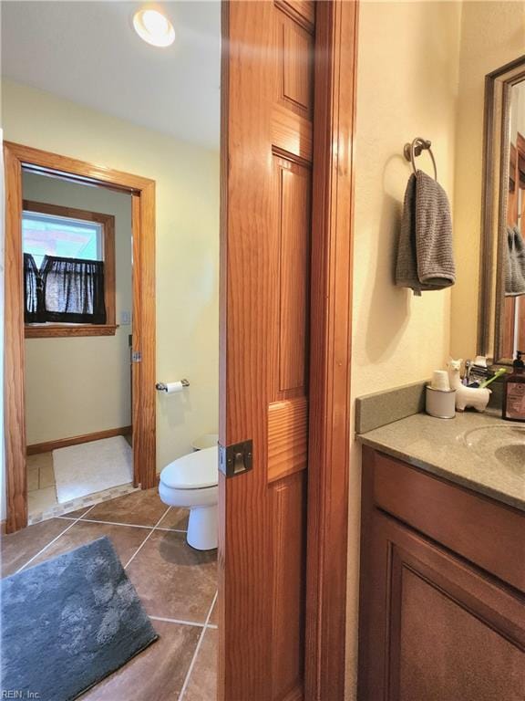 bathroom with tile patterned flooring, vanity, and toilet