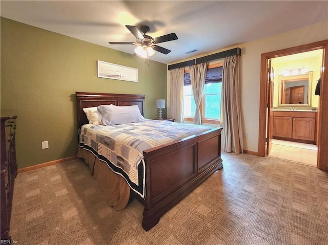 bedroom with light carpet, connected bathroom, and ceiling fan