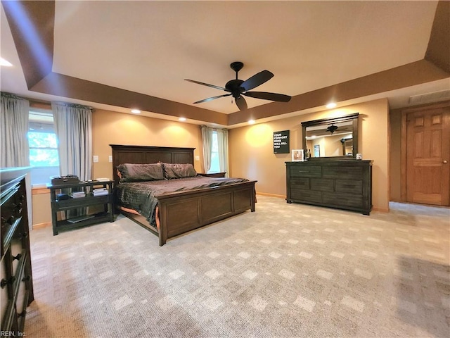 bedroom featuring a tray ceiling, ceiling fan, and light colored carpet