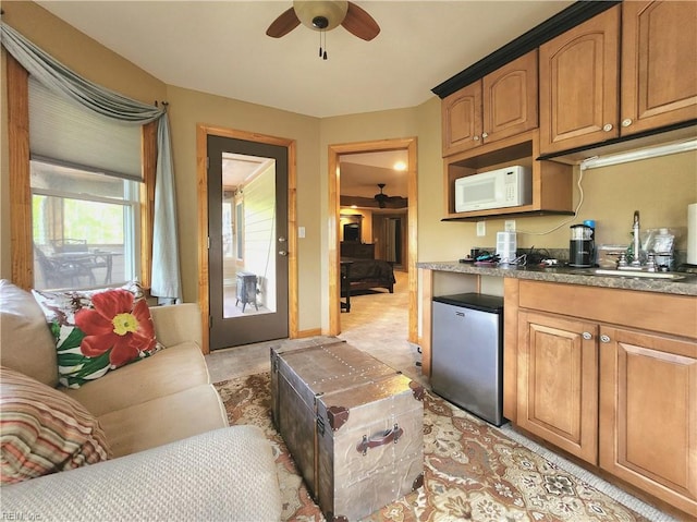 kitchen with ceiling fan, sink, and stainless steel fridge