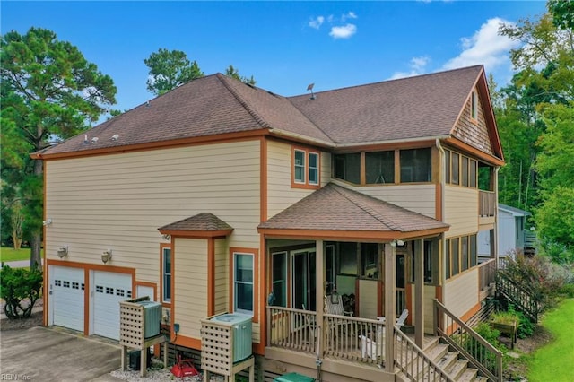 back of property with a sunroom and a garage