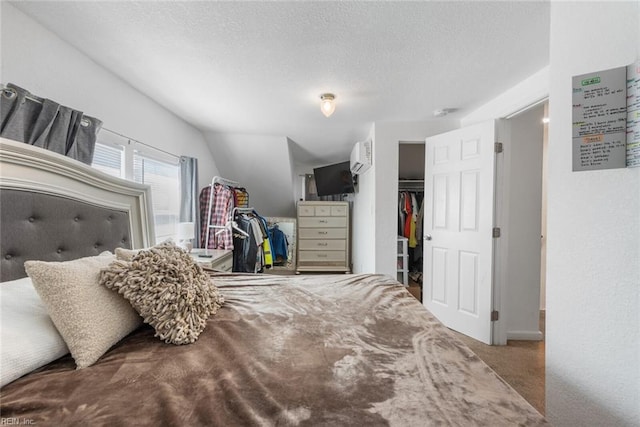 carpeted bedroom with a textured ceiling, a closet, and a wall unit AC