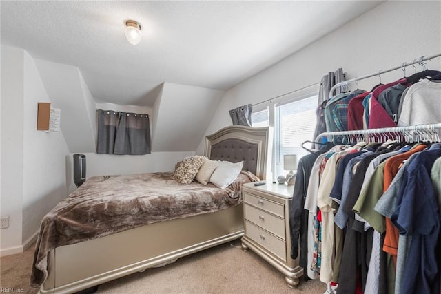 carpeted bedroom with lofted ceiling