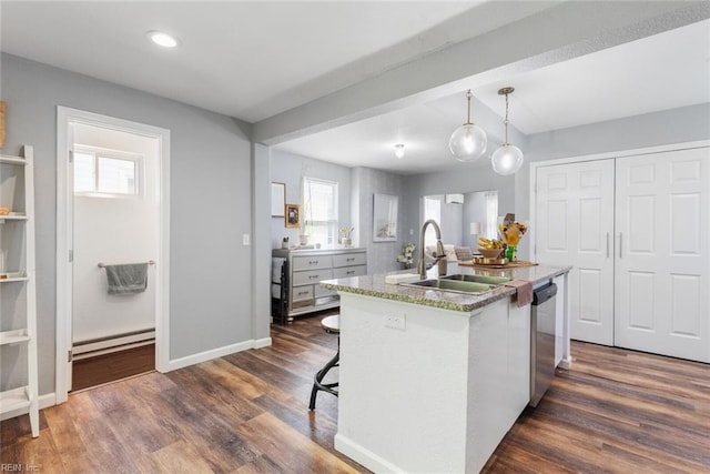 kitchen with sink, stainless steel dishwasher, a kitchen island with sink, decorative light fixtures, and dark hardwood / wood-style floors