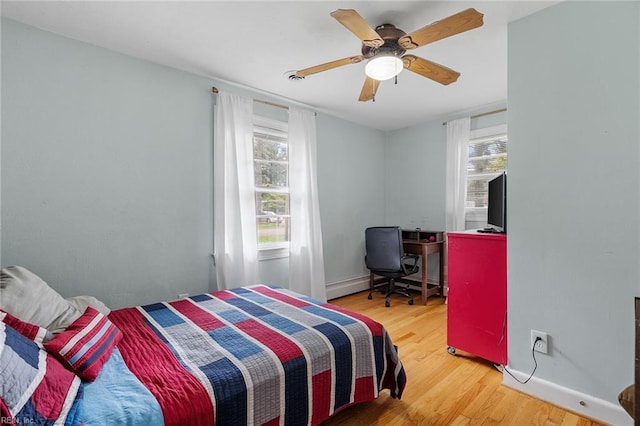 bedroom with a baseboard radiator, wood-type flooring, and ceiling fan