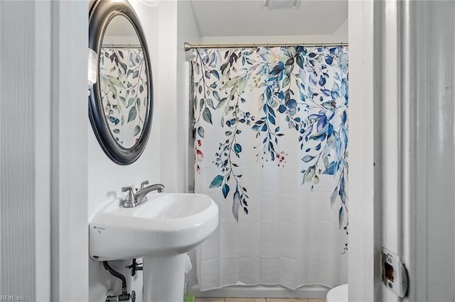 bathroom featuring walk in shower and toilet