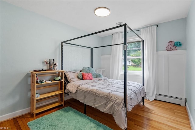 bedroom with wood-type flooring and a baseboard radiator