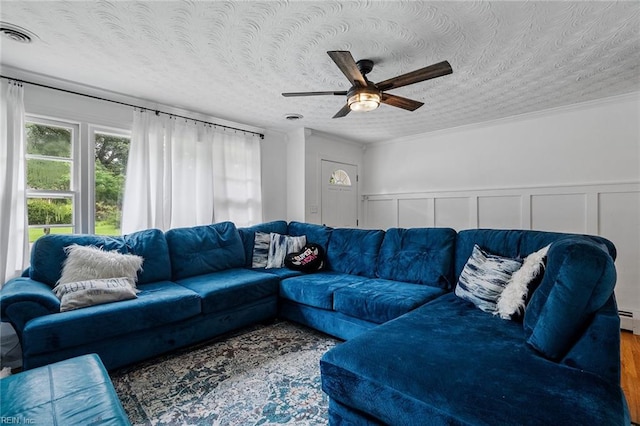 living room with ceiling fan, a textured ceiling, crown molding, and hardwood / wood-style flooring