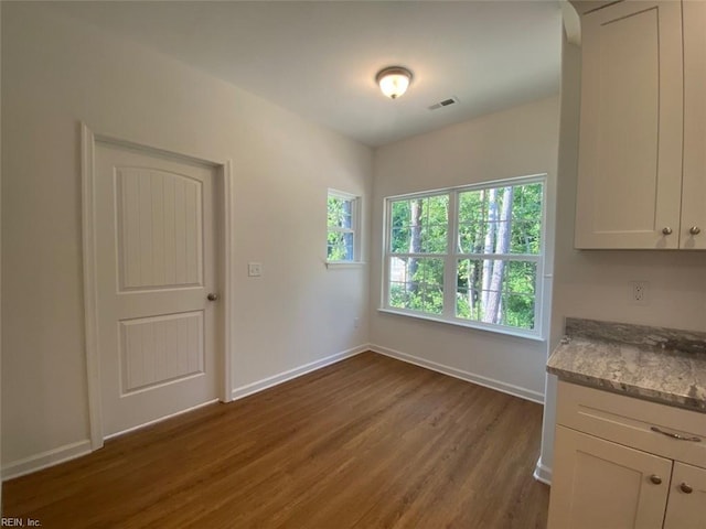 unfurnished dining area featuring dark hardwood / wood-style flooring