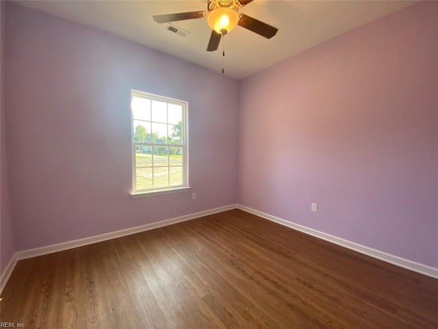 empty room featuring ceiling fan and dark hardwood / wood-style flooring