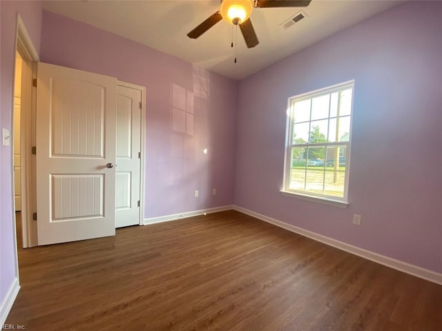 empty room with ceiling fan and dark wood-type flooring