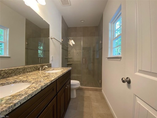 bathroom with vanity, toilet, a shower with door, and tile patterned floors