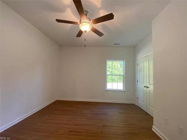 unfurnished room with ceiling fan and dark hardwood / wood-style flooring