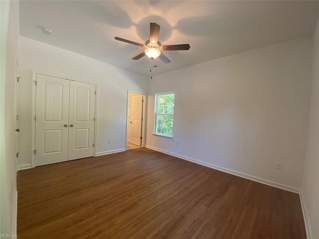 unfurnished bedroom with ceiling fan and dark hardwood / wood-style flooring