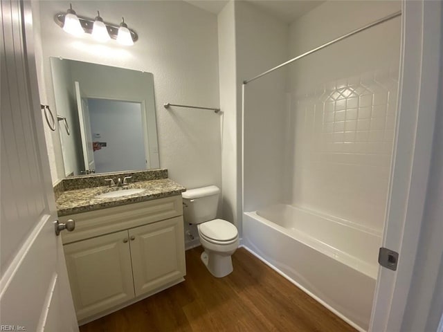 full bathroom with washtub / shower combination, hardwood / wood-style flooring, vanity, and toilet