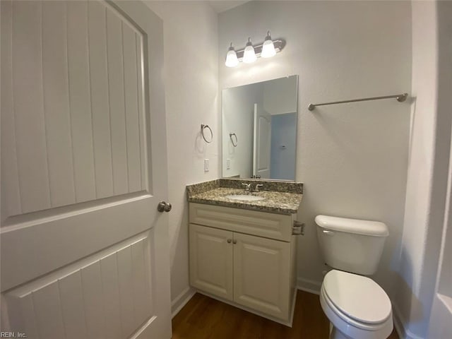 bathroom with vanity, hardwood / wood-style floors, and toilet