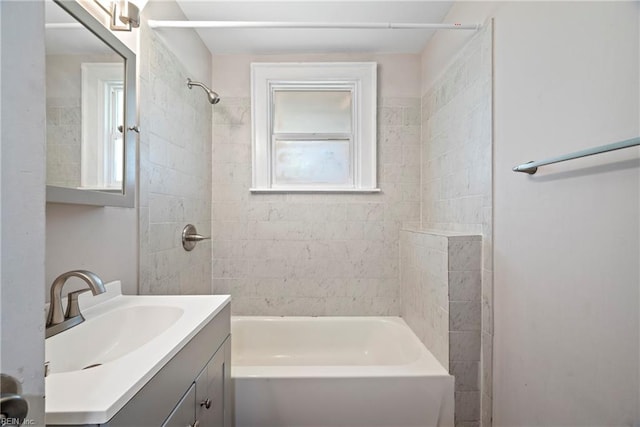 bathroom featuring vanity, tiled shower / bath combo, and a wealth of natural light