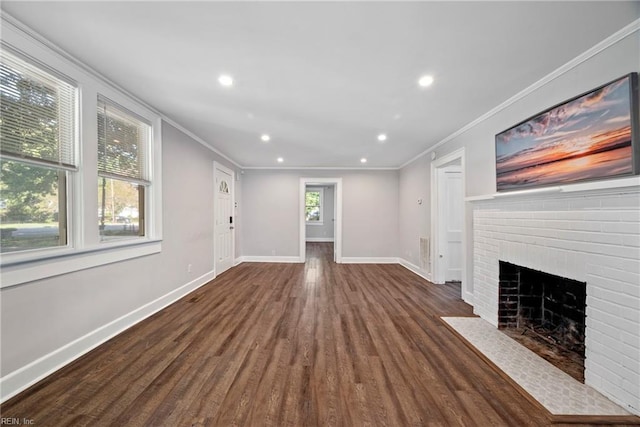 unfurnished living room featuring crown molding, dark wood-type flooring, and a brick fireplace