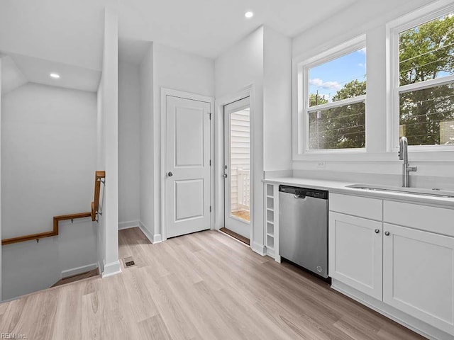 kitchen featuring white cabinets, light hardwood / wood-style floors, sink, and stainless steel dishwasher