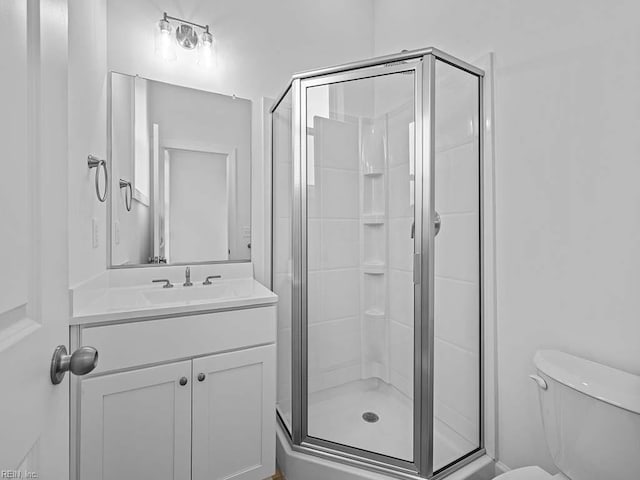 bathroom with walk in shower, vanity, and toilet